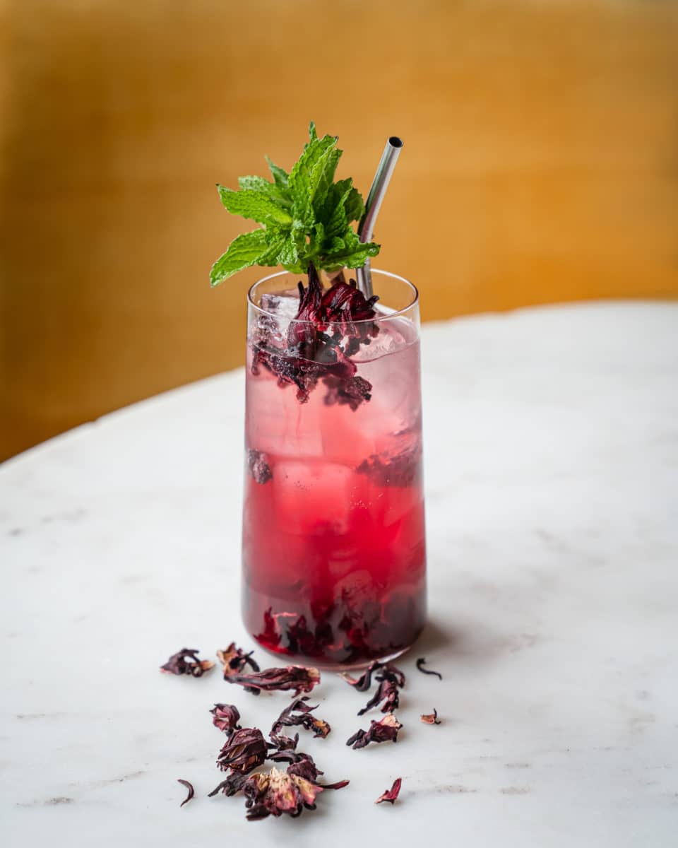 red mojito sitting on a table with garnish